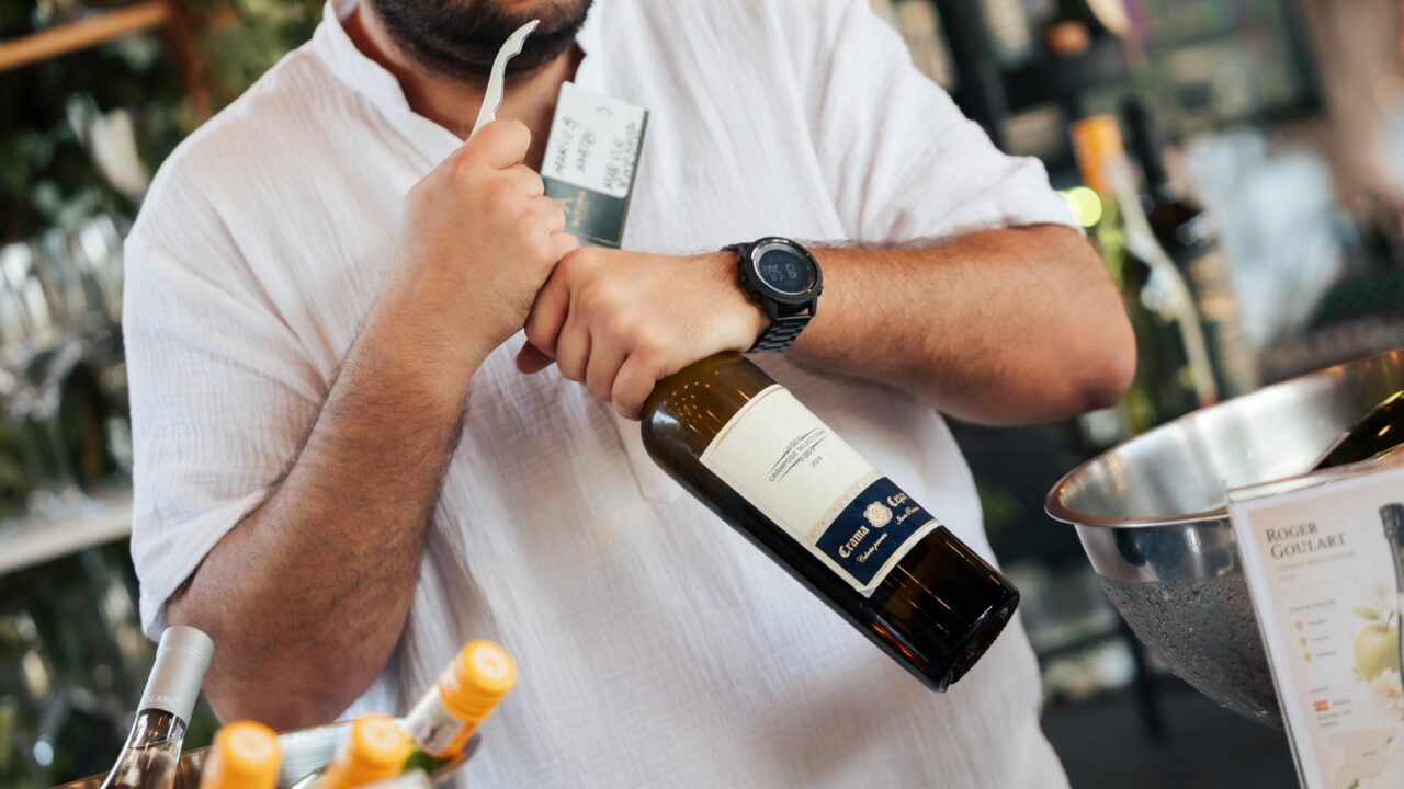 Barman Shaker Bar deschizând o sticlă de vin la bar