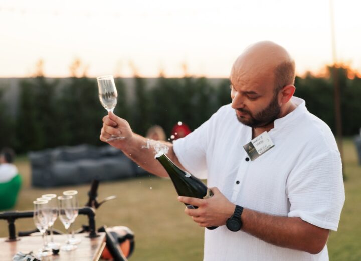 Barman Shaker Bar deschide o sticlă de prosecco lângă moto-bar, la apus